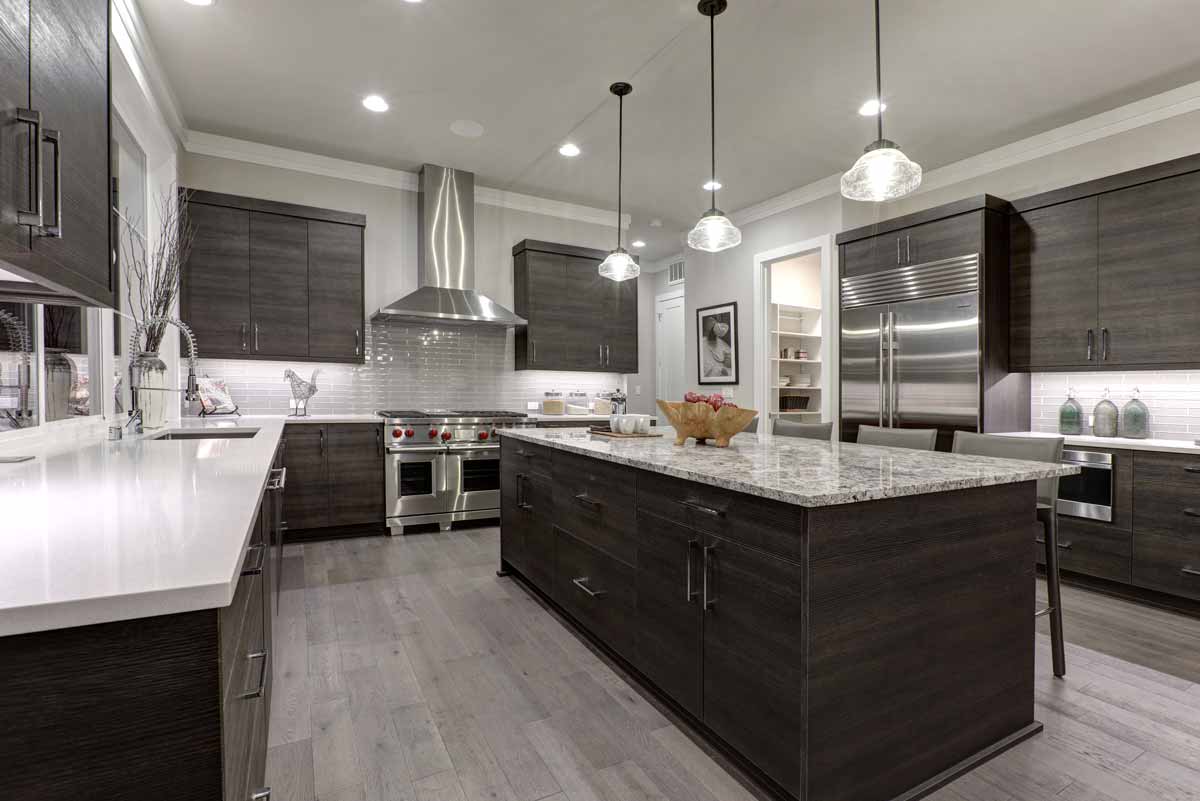 A nice kitchen with granite countertops, dark wood cabinets and stainless steel appliances